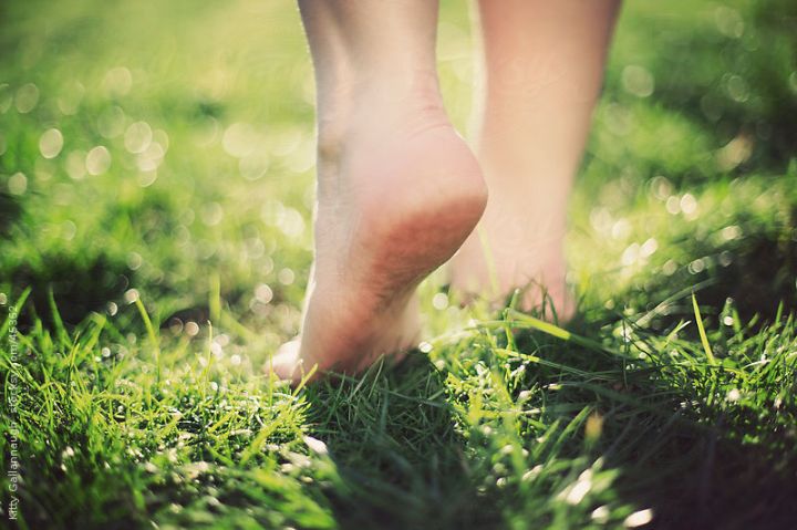 Walking barefoot across the grass.